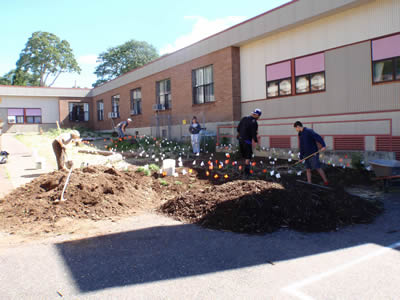 volunteers helping to weed and mulch new plantings at the Native Pollinator Garden